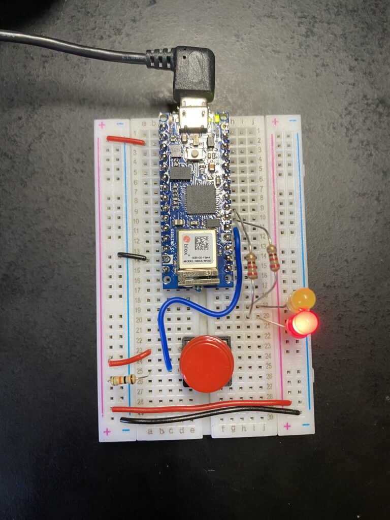 Arduino Nano on breadboard with lit red LED
